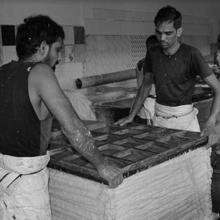 two men readying the pressing process for making cotton paper