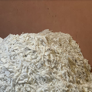 a pile of cotton garment cutting waste from the fashion industry in a corner of a warehouse