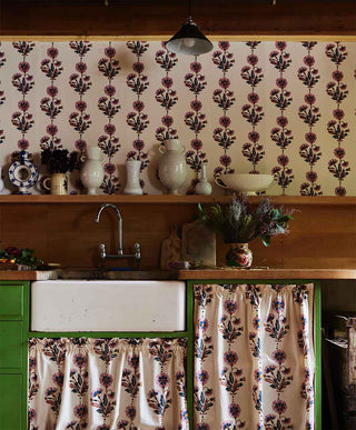 Image of a kitchen with flowers ready to be arranged into a bouquet. On the wall Molly Mahons new Dianthus design wallpaper in the rust/rose colourway.
