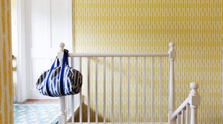 Molly Mahon fern wallpaper hand block design bringing a beautiful warm yellow light to a stairway landing hall