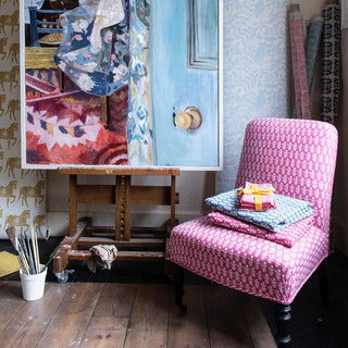 Molly Mahon Bagru pink design fabric upholstered on an armchair sat next to a oil painting