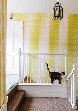 A landing wallpapered in Fern Mustard which gives a warming brightness to the space
