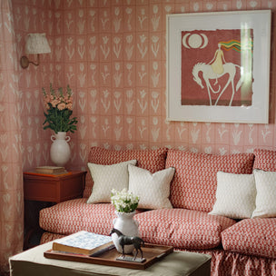 Living room with a red and white patterned sofa, floral wallpaper, and decorative items.