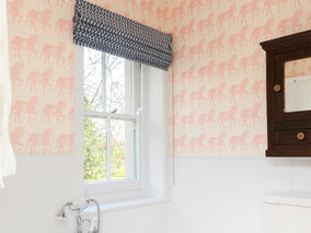 molly mahon hnad block printed wallpaper marwari horse design in pink set in a tall bathroom above a white wooden valance